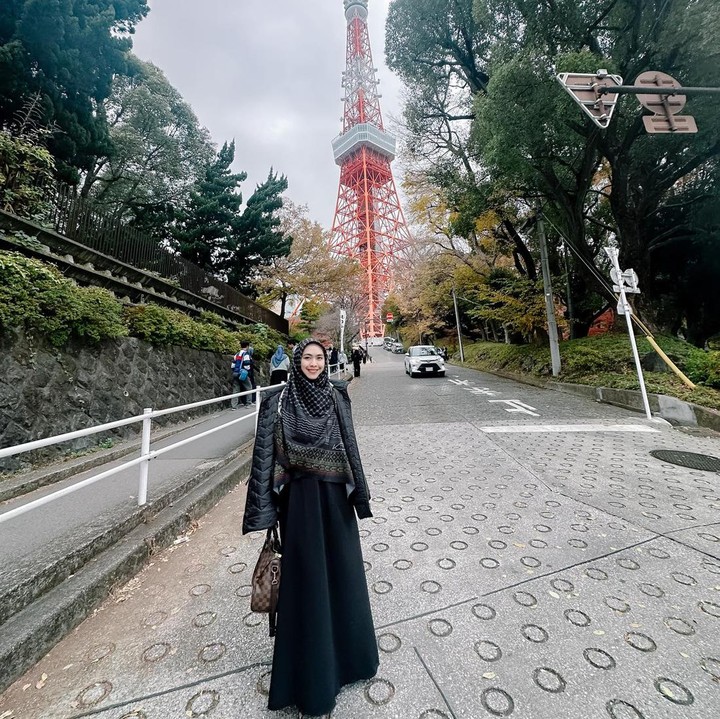 <p>Bunda yang ingin tampil dengan warna serba hitam juga bisa mengenakan gamis dan jaket kulit seperti Oki. Padukan dengan hijab motif untuk sentuhan manis. (Foto: Instagram @okisetianadewi)</p>