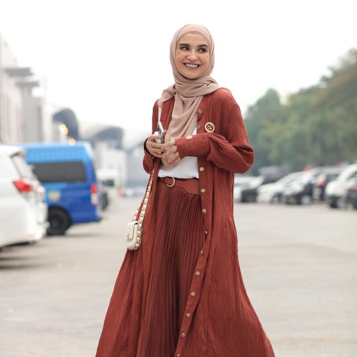 <p><em>Modest fashion</em> dengan gaya kasual juga bisa diterapkan lewat padu padan kaus dan <em>pleated skirt.</em> Shireen menambahkan<em> long outer</em> berwarna <em>terracotta</em> yang senada dengan roknya. (Foto: Instagram @shireensungkar)</p>