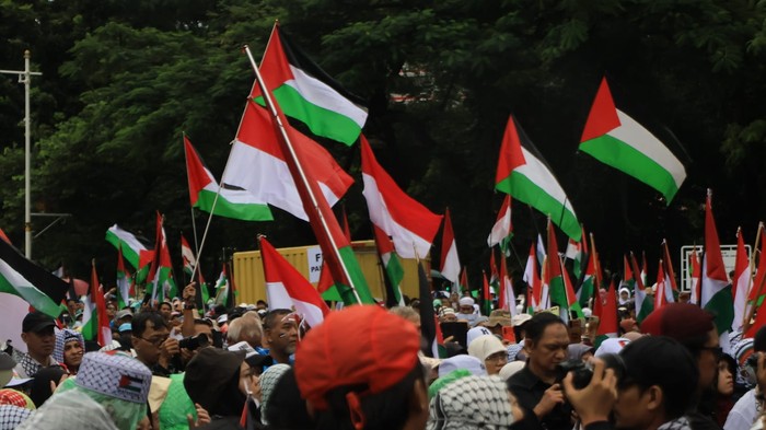 Meski diguyur hujan, massa bela Palestina tetap melakukan aksi di depan kedutaan besar Amerika Serikat, Jakarta. Nih potretnya.