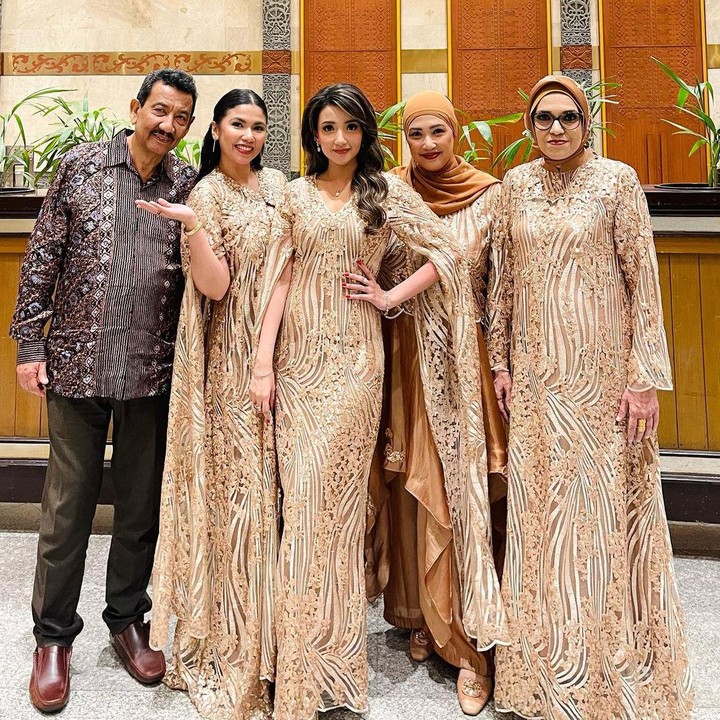 <p>Tsania tidak sendiri. Bunda dua anak ini datang bersama keluarganya. Anggota keluarga perempuan yang datang kompak mengenakan gaun berwarna gold dengan motif serupa. (Foto: Instagram @tsaniamarwa54)</p>