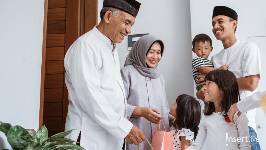 Ilustrasi Lebaran silaturahmi thr Happy asian muslim aged couple meeting kids and grand children at doorstep during eid mubarak celebration