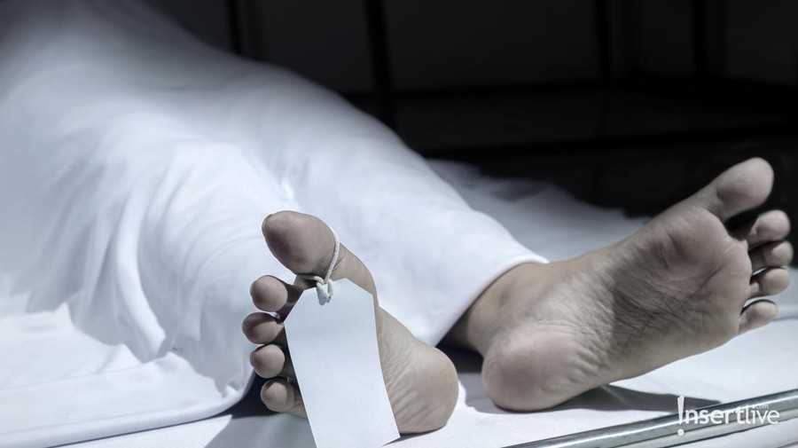 Human corpse covered with a sheet and name tag on toe in the morgue