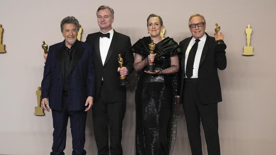 Christopher Nolan poses in the press room with the awards for best director and best picture for 