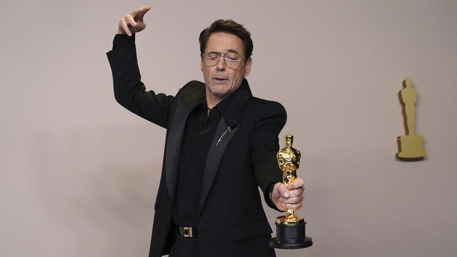 Robert Downey Jr. poses in the press room with the award for best performance by an actor in a supporting role for 