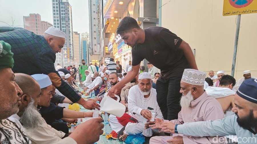 Seorang pria membagikan susu kepada jemaah di Masjidil Haram untuk berbuka puasa, Senin (11/3/2024).
