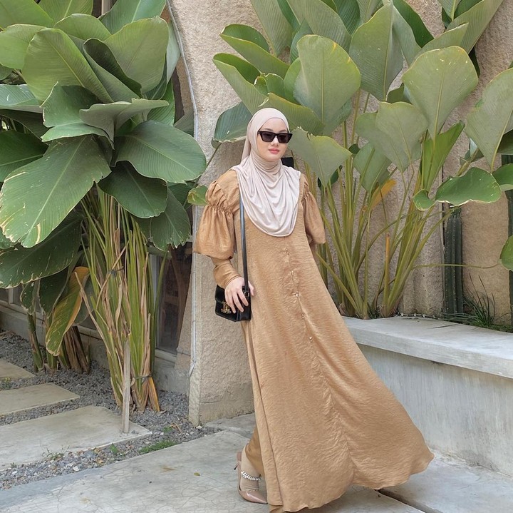 <p>Warna-warna bumi seperti cokelat dan <em>beige</em> banyak diterapkan pada gaya busana bernuansa <em>earth tone.</em> Untuk tampilan <em>chic,</em> Bunda bisa gunakan<em> </em>gamis beraksen <em>balloon sleeve</em> sebagai busana Ramadhan dan Idul Fitri. (Foto: Instagram @dindahw)</p>