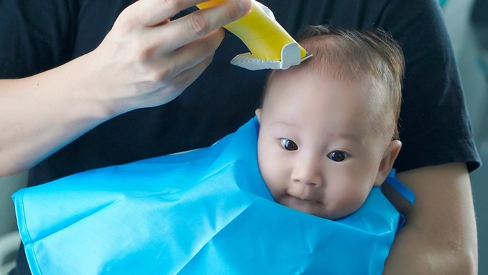 Ilustrasi Mencukur Rambut Bayi
