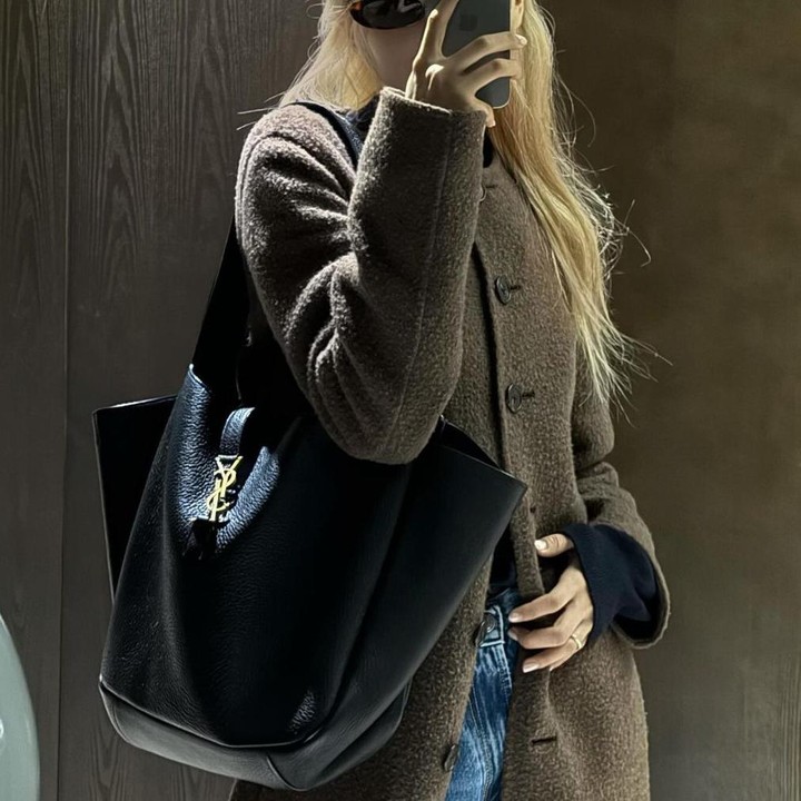 <p>Menjadi <em>brand ambassador</em> Saint Laurent, Rose tampak <em>fashionable</em> dengan <em>tote bag</em> hitam rancangan desainer Italia tersebut yang menyempurnakan coat berwarna cokelat berpadu dengan celana jeansnya. (Foto: Instagram @roses_are_rosie)</p>