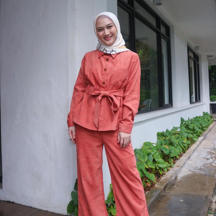 <p>Tak kalah modis, ada gaya bukber kantor dengan setelan <em>outfit</em> berwarna <em>peach</em> seperti yang dikenakan oleh Melody. Kemeja dengan aksen tali bisa mempermanis penampilan Bunda. Selain itu, celana bahan bersiluet longgar dapat menjadi pilihan pas untuk busana kantor. (Foto: Instagram @melodylaksani92)</p>