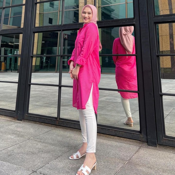 <p>Bunda juga bisa memberi sentuhan <em>colorful</em> lewat busana berwarna cerah. Melody mengenakan atasan berwarna<em> shocking pink</em> yang dipadukan bersama celana dan sepatu <em>heels</em> putih polos. (Foto: Instagram @melodylaksani92)</p>