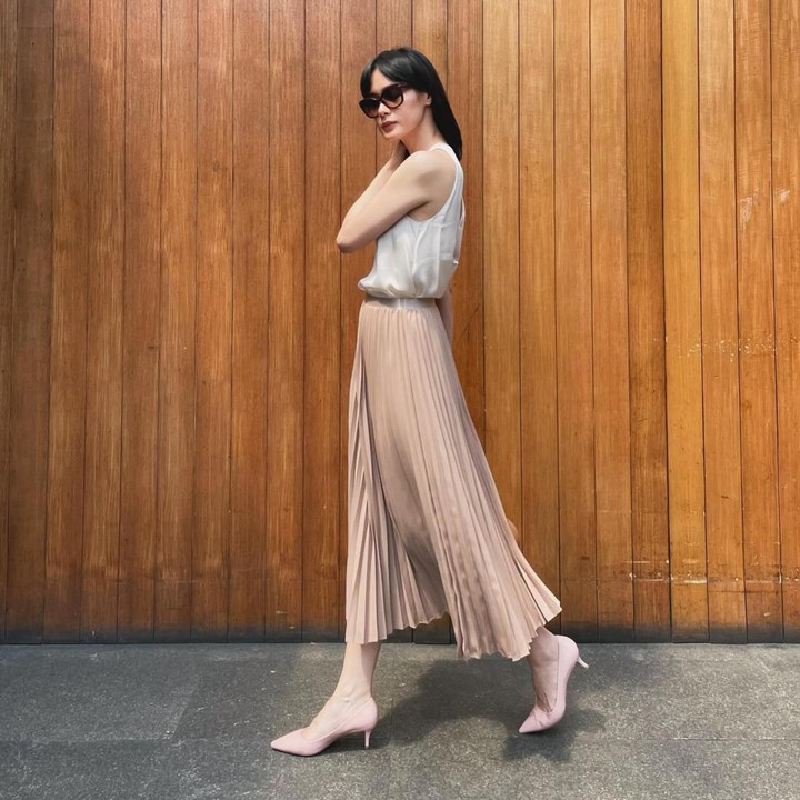 <p>Renata juga tampil memesona dengan rok plisket yang dipadukan bersama<em> sleveless shirt</em>. Meski terkesan santai, busananya tetap elegan dengan sentuhan feminin dari <em>kitten heels</em> di kakinya. (Foto: Instagram @renata711)</p>