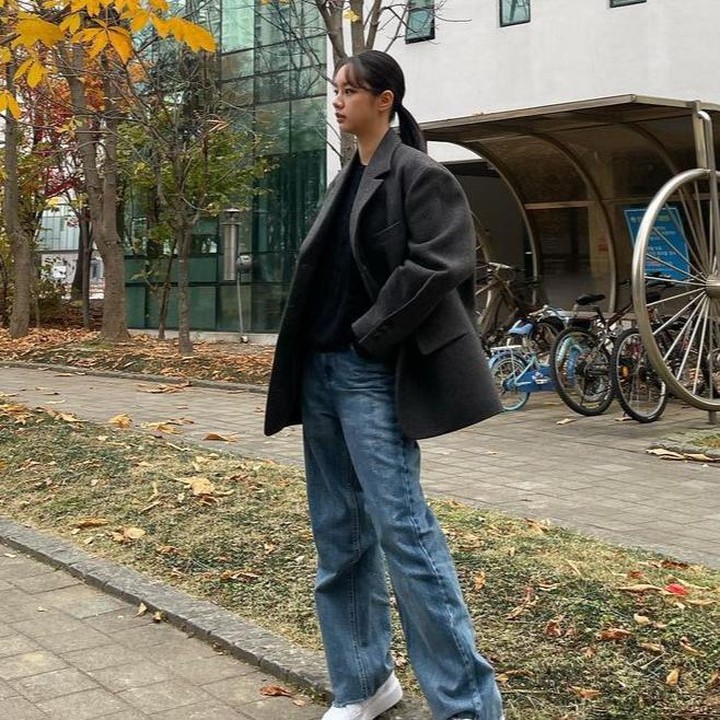 <p>Hyeri berpose di dekat pohon musim gugur dalam balutan blazer dan top serba hitam serta celana jeans biru plus sneaker putih yang membuatnya tampak kasual. (Foto: Instagram @hyeri_0609)</p>
