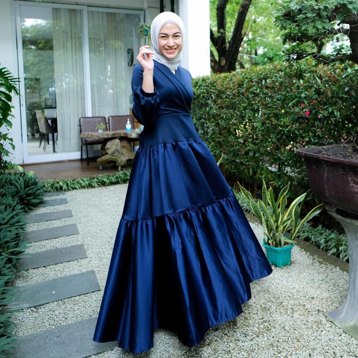 <p>Nina Zatulini terlihat elegan dengan <em>ruffle dress</em> berbahan satin. Pilihan warna gelap seperti <em>navy</em> bisa digunakan ketika Bunda sedang jenuh dengan warna cerah. (Foto: Instagram @ninazatulini22)</p>