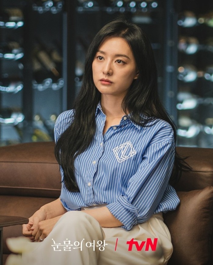 Bagi Beauties yang ingin tampil mewah namun effortless bisa mencoba gaya Hong Hae In ini yang tampak modis dalam padu padan blouse biru yang bagian lengannya digulung sampai siku bergaris dan celana panjang ivory./ Foto: tvN