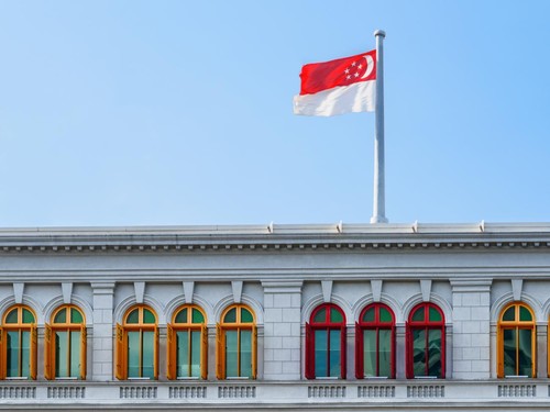 The Flag of Singapore fluttering over the Ministry of Communications and Information. Singapore is a popular tourist destination of Asia.