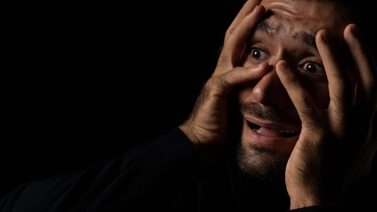 Pria ketakutan Frightened young beard man afraid scared and terrified with fear expression face He put hands on face Young guy were shock and panic in the horror dark room Emotional and facial expression concept