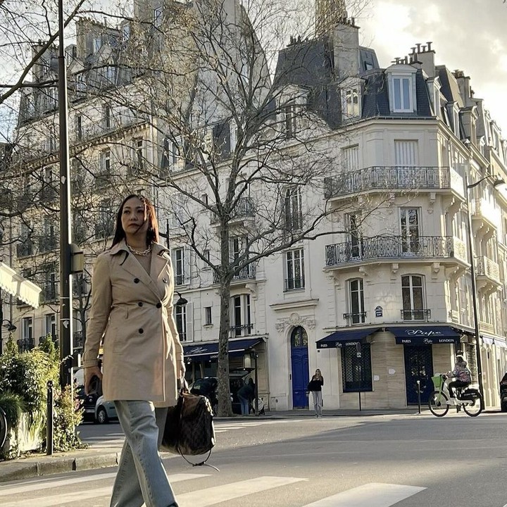 <p>Tidak hanya itu, perempuan kelahiran 1978 ini juga mengunggah fotonya saat sedang menyebrangi jalanan di Paris. Sudah seperti warga lokal, Bunda dari Naura Ayu ini menggunakan trench coat ala Parisian yang sangat modis, lho. (Foto: Instagram @riafinola).</p>