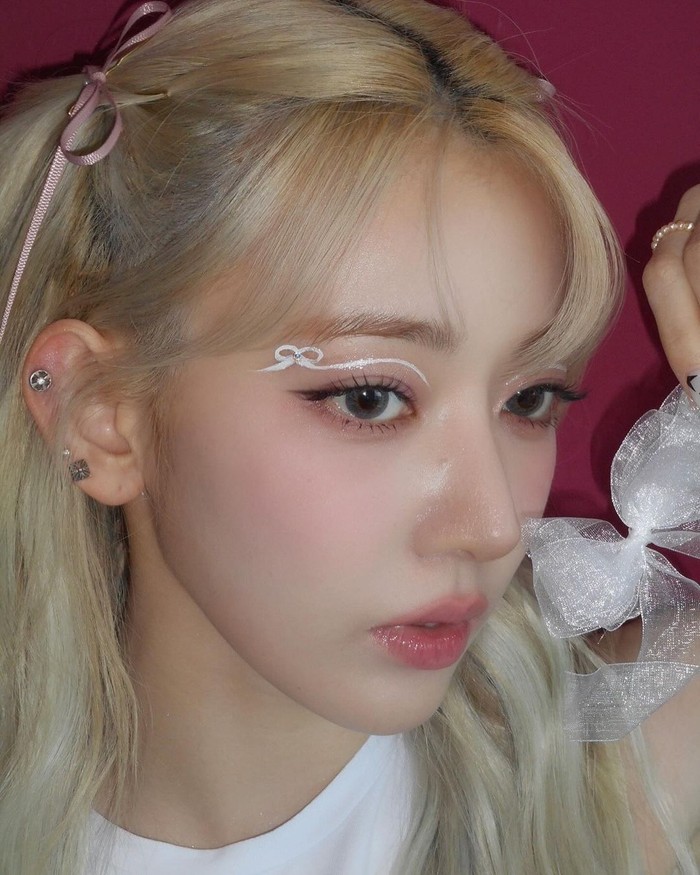 Bows dan gaya coquette menjadi tren tidak hanya di dunia KPop. Sakura meningkatkan gaya makeup dengan liner super detail di bawah alisnya, dan menambah kristal kecil di bagian tengah yang membuat tampilannya lebih menarik./ Foto: Instagram/39saku_chan