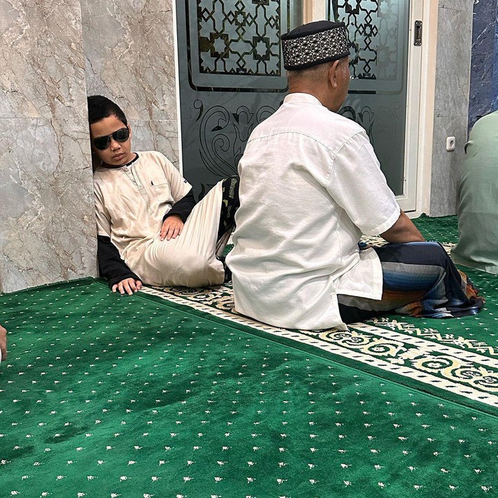 <p>"<em>Maasyaa Allah Tabarakallah.</em> Kemarin Adam sempat salat Subuh sambil merem. Abi bilang usahakan buka matanya. Tapi Adam bilang silau. Akhirnya coba solusi dengan memakai kacamata hitam. Alhasil seperti ini jadinya," tulis Wisnu seraya membagikan momen kala Adam tertidur sambil bersandar di masjid. (Foto: instagram: @teukuwisnu)</p>