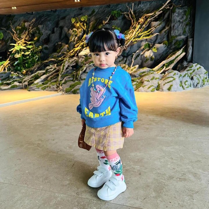 <p>Ameena pernah memadukan <em>sweater crewneck</em> warna biru langit dengan rok pendek kotak-kotak. Penampilannya ini semakin menggemaskan dengan rambut yang dikuncir dua. (Foto: Instagram: @ameenaatta)</p>