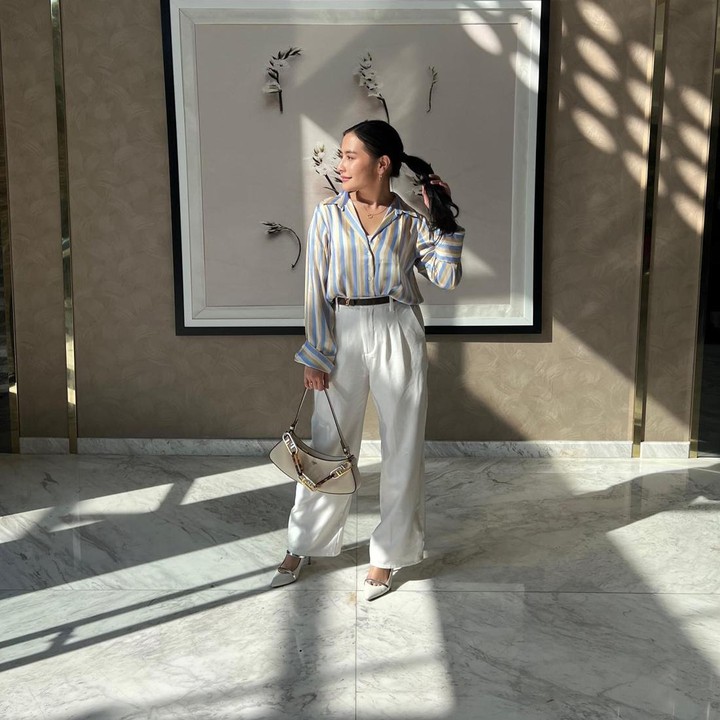 <p>Permainan motif <em>stripes</em> juga bisa dijadikan sebagai busana kantor. Prilly mengenakan kemeja bercorak garis-garis dengan aneka warna <em>colorful.</em> Padukan bersama celana bahan berwarna polos, ya. (Foto: Instagram @prillylatuconsina96)</p>