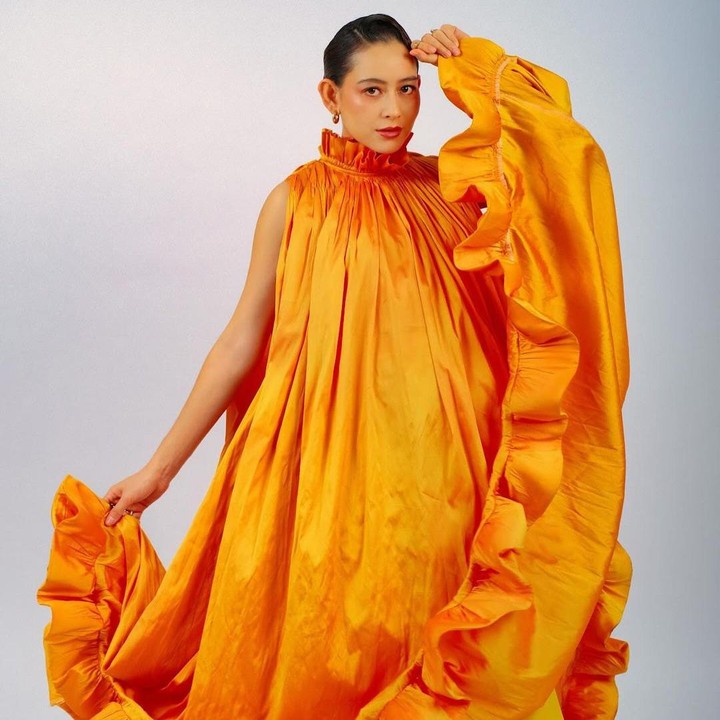 <p>Tak hanya melakukan maternity shoot dengan satu pakaian saja, Laura juga membagikan hasil fotonya dengan konsep lain. Kali ini, perempuan keturunan Bali dan Prancis tersebut menggunakan gaun oranye, Bunda. (Foto: Instagram @laura_theux).</p>