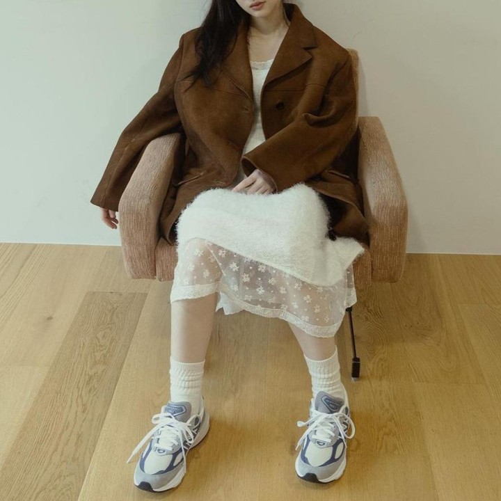 <p>Member ILLIT lainnya yaitu Minju yang mengenakan <em>laced midi</em> dress berwarna putih dan dipadukan dengan blazer berwarna cokelat, membuatnya terlihat cantik dan manis. (Foto: Instagram @illit_official)</p>