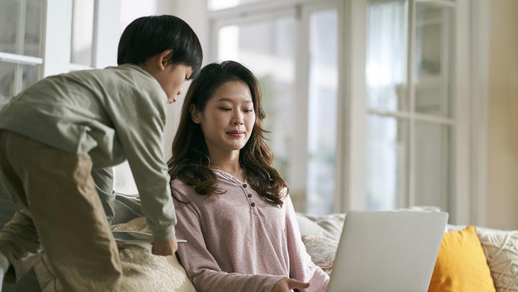 young asian businesswoman mother trying to work at home annoyed by hyperactive son