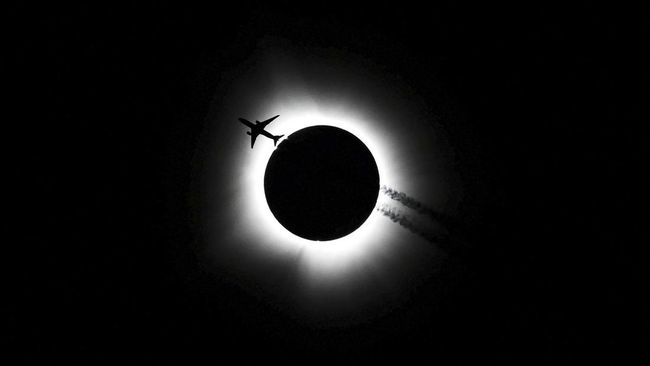 An airplane passes near the total solar eclipse during the Hoosier Cosmic Celebration at Memorial Stadium in Bloomington, Indiana, U.S. April 8, 2024. Bobby Goddin/USA Today Network via REUTERS
NO RESALES. NO ARCHIVES. MANDATORY CREDIT     TPX IMAGE