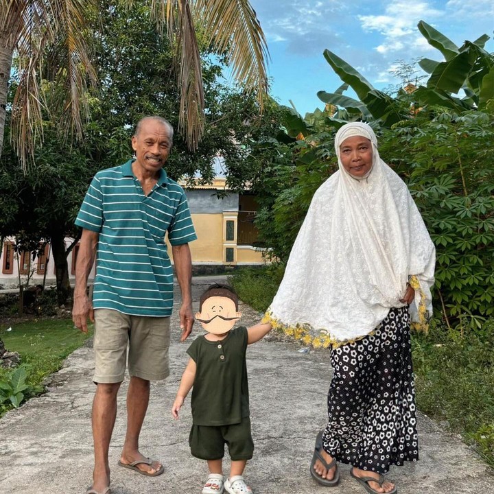 <p>Bahkan, saat merayakan Idul Fitri, sang putra terlihat tidak lepas dari genggaman kakek dan neneknya, lho, Bunda. (Foto: Instagram@indahpermatas)</p>