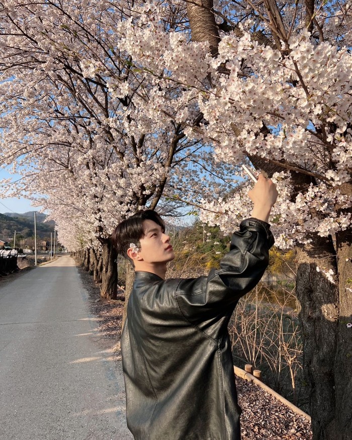 Idol-aktor dengan pesona mendebarkan hati yang tak lekang oleh waktu yaitu Kim Myung Soo mengambil potret selca dirinya dengan latar cuaca cerah di musim semi serta bunga sakura bewarna merah muda yang diselipkan di telinga./ Foto: instagram.com/kim_msl