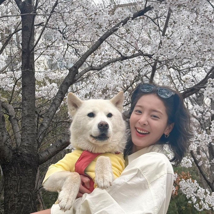 Tidak sendirian, Seol In Ah menikmati hari-hari yang bersemi indah bersama anjing peliharaannya yaitu Jullie. Keduanya tersenyum cerah dalam momen kebersamaan berlatarkan keindahan bunga yang terabadikan, Beauties./ Foto: instagram.com/_seorina
