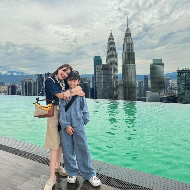 <p>Dalam salah satu unggahan, Ayu Ting Ting tampak berpose di <em>rooftop</em> gedung yang memiliki <em>infinity pool.</em> Ayu terlihat memeluk sang putri dengan penuh sayang, Bunda. (Foto: Instagram @ayutingting92)</p>