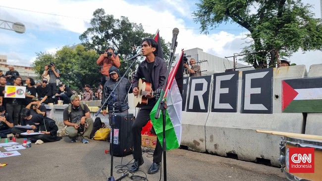 Lagu, puisi hingga orasi digaungkan saat massa menggelar unjuk rasa membela Palestina di depan Kedubes Amerika Serikat. Massa menggunakan pakaian serba hitam. 