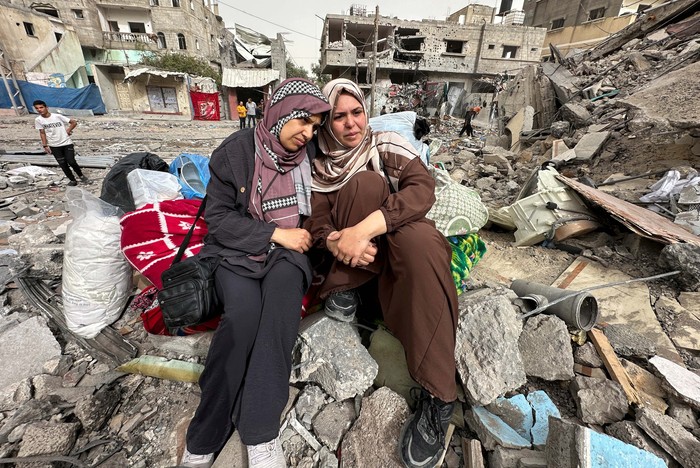 Palestinian women react as they sit on the rubble of a residential building housing their apartments, following an Israeli raid, amid the ongoing conflict between Israel and the Palestinian Islamist group Hamas, in Nuseirat, in the central Gaza Strip, April 18, 2024. REUTERS/Doaa Rouqa
