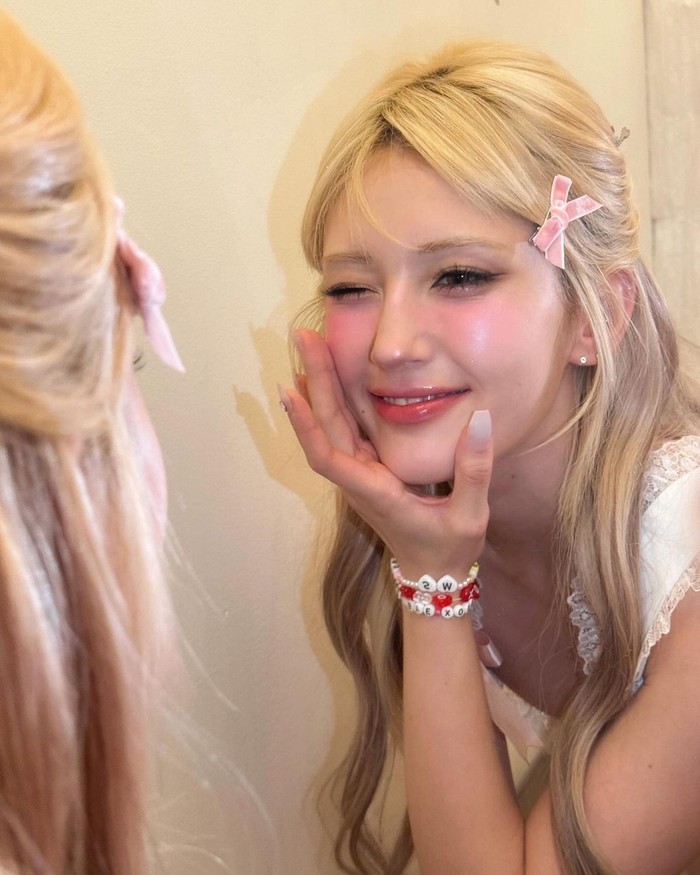 Alih-alih menggunakan eyeshadow warna-warni, Somi membuat matanya terlihat jernih dengan bulu mata yang lentik dan blush on berwarna alami untuk memberikan kilau merah muda yang lembut./ Foto: Elle Korea