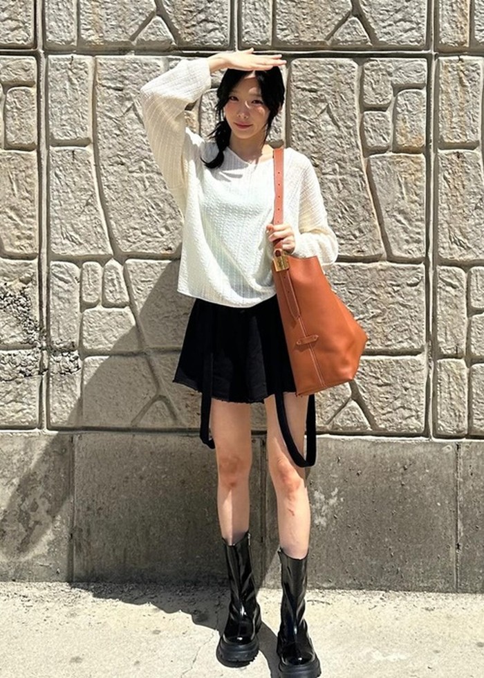 Taeyeon SNSD tampil feminin dengan rok hitam yang dipadu dengan long sleeve shirt longgar berwarna putih. Gaya ini juga cocok dipakai untuk nge-date lho, Beauties!/Foto: Instagram/taeyeon_ss