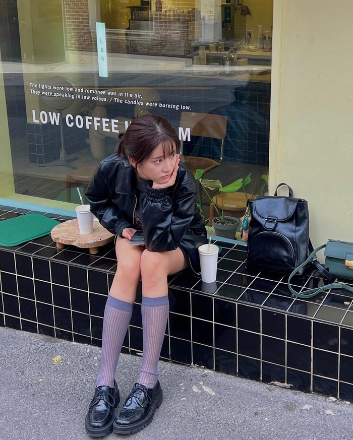 Tampilan Exi WJSN tertuju pada kaus kaki selutut yang mencolok. Outfit yang ia kenakan semuanya berwarna hitam, dan kaus kaki berwarna ungu menjadi item yang menarik dalam tampilannya yang terlihat chic./ Foto: Elle Korea