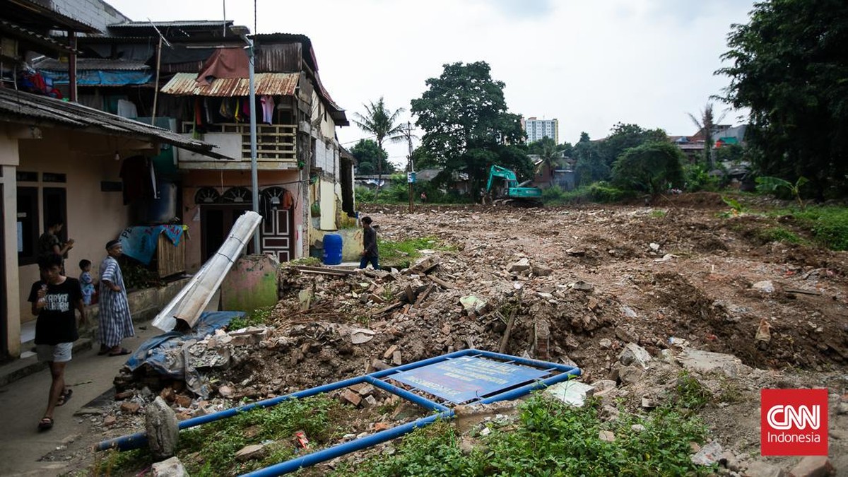 FOTO: Tatapan Pasrah Warga pada Alat Berat Normalisasi Kali Ciliwung