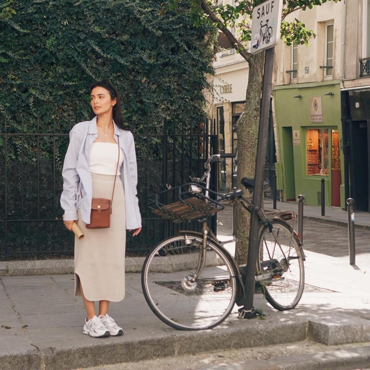 <p>Ketika berpetualang di Paris, Amanda juga tampil modis dengan kemeja bermotif <em>stripes</em> dan <em>tanktop</em> putih. Ia kemudian memakai <em>pencil skirt</em> dan sepatu <em>sneakers</em> kasual. (Foto: Instagram @amandarawles)</p>
