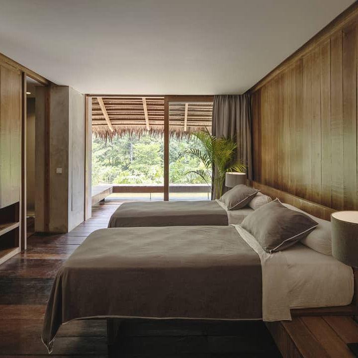 <p>Kamar di penginapan milik Nicholas Saputra juga didesain dengan dominasi kayu cokelat. Setiap kamar dirancang dengan konsep yang nyaman, dengan pintu dan jendela besar yang menyatu, di mana tamu bisa melihat pemandangan alam dari dalam kamar. (Foto: Instagram @nicholassaputra @terrariotangkahan)</p>