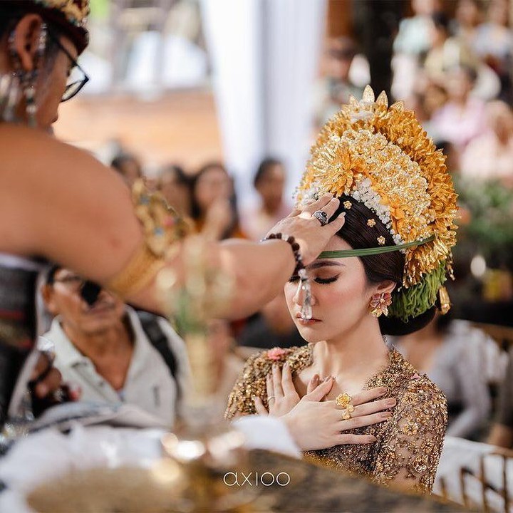 <p>Acara dilanjutkan dengan upacara Mepamit, Bunda. "Bermakna calon pengantin wanita (pradana) meminta izin kepada para leluhurnya untuk menikah dan selanjutnya menjadi tanggung jawab calon pengantin pria (purusha) dan keluarganya di masa depan," sambung mereka. (Foto: Instagram @rfasmusic @rizkyfbian)</p>