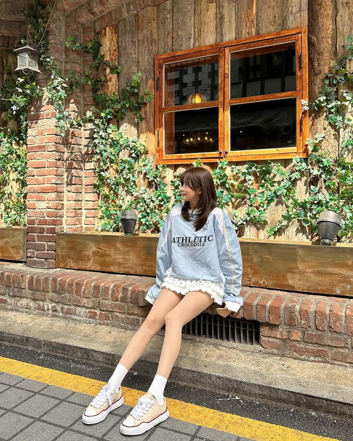 Han Bo Reum tampil imut dengan memadukan sweatshirt biru muda dengan rok ruffle putih, dan diakhiri dengan sneakers. Ia tampil sporty dan menetralkan mood girly yang menjadikannya tetap stylish./ Foto: Elle Korea