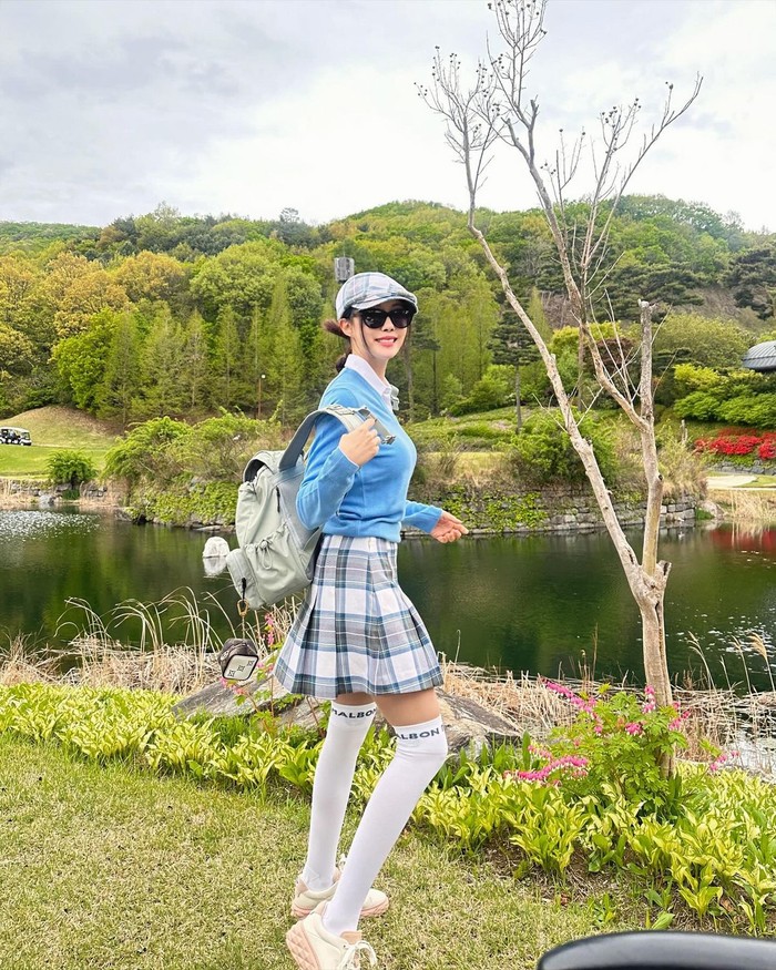 Hyomin tampil mengesankan dengan sweater biru di atas kemeja pique, yang dipadukan dengan rok lipit kotak-kotak tartan dan kaus kaki selutut untuk melengkapi gaya preppy yang trendi./ Foto: Elle Korea