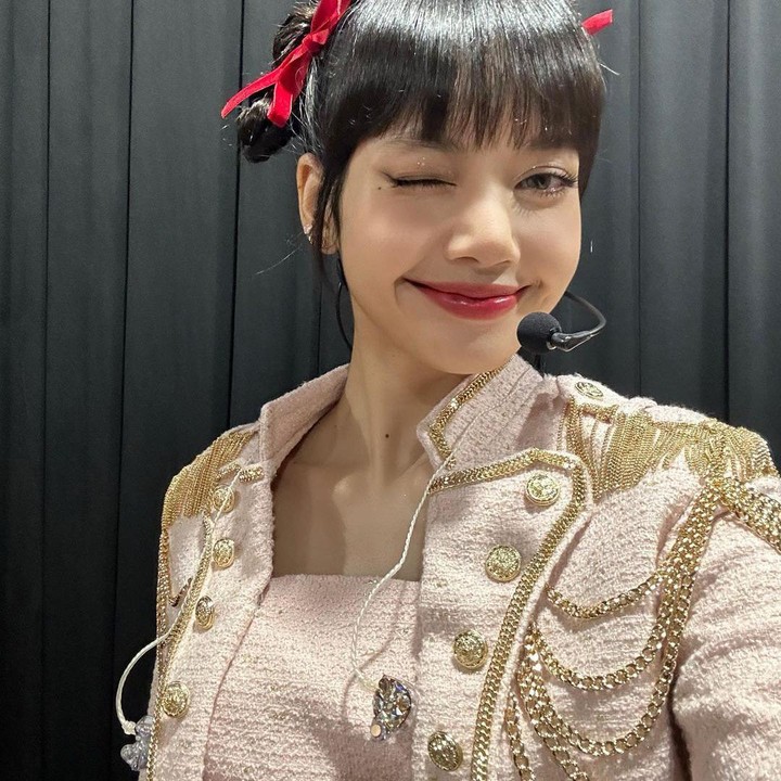 <p>Kalau Bunda memiliki rambut lebat, mungkin Bunda bisa mencoba gaya Lisa BLACKPINK di potret ini. Kepangan di dua sisi rambut akan digulung membentuk pucca hair yang dipadukan pita merah yang cantik. (Foto: Instagram @lalalalisa_m)</p>