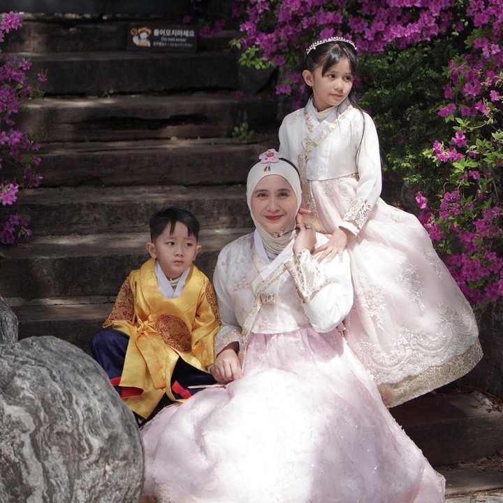 <p>Qiara terlihat cantik mengenakan Hanbok bernuansa putih dan merah muda yang mirip dengan sang Bunda. Penampilannya pun semakin menawan dengan bando dan tas tangan warna senada. (Foto: Instagram: @ryana_dea)</p>