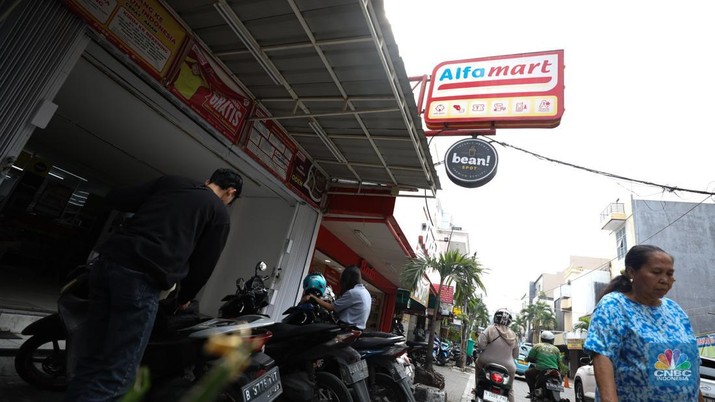 Aktivitas seorang warga menjaga kendaraan di salahsatu minimarket di kawasan Jakarta, Rabu (8/4/2024). (CNBC Indonesia/Tri Susilo)