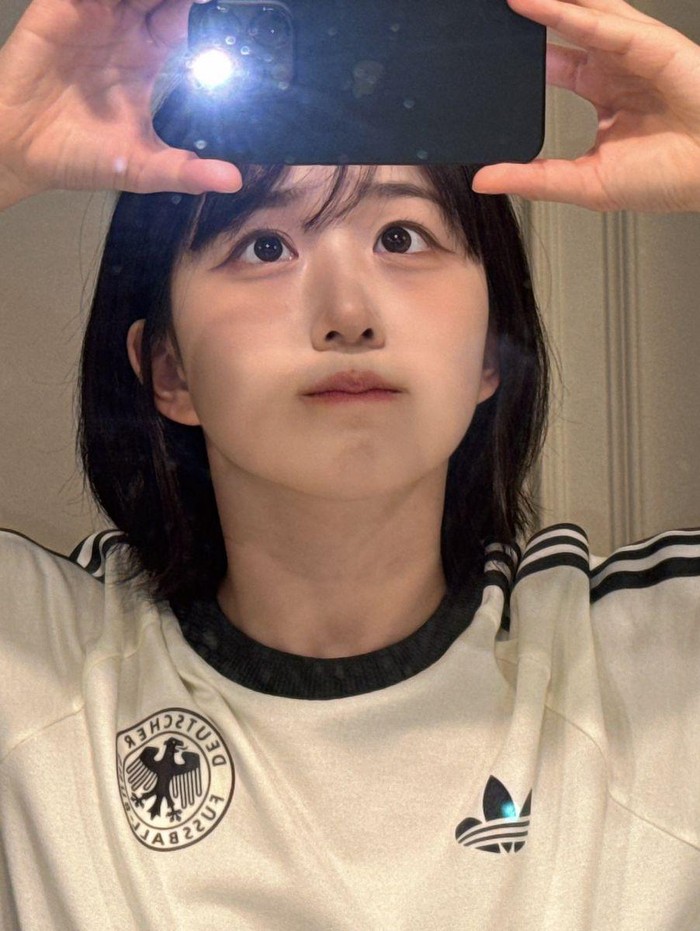 Haewon terlihat sederhana dan minimalis dengan jersey DFB. Penampilannya terlihat santai dan nyaman, serta menunjukkan gaya kasual yang cocok dikenakan ketika sedang berjalan-jalan santai./ Foto: Instagram/nmixx_official