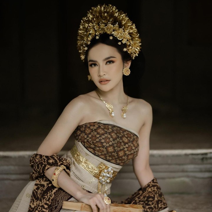 <p>Ketika melakukan sesi <em>pre wedding,</em> Mahalini tampil memesona dengan busana adat Bali berwarna cokelat. Bajunya dilengkapi dengan selendang bercorak senada. <em>Headpiece</em> tradisional di kepalanya membuat Mahalini tampak sangat anggun. Tak hanya itu, penampilannya disempurnakan dengan berbagai perhiasan bernuansa emas. (Foto: by @axioo @emanuel_ak from Instagram: @rizkyfbian @mahaliniraharja)</p>