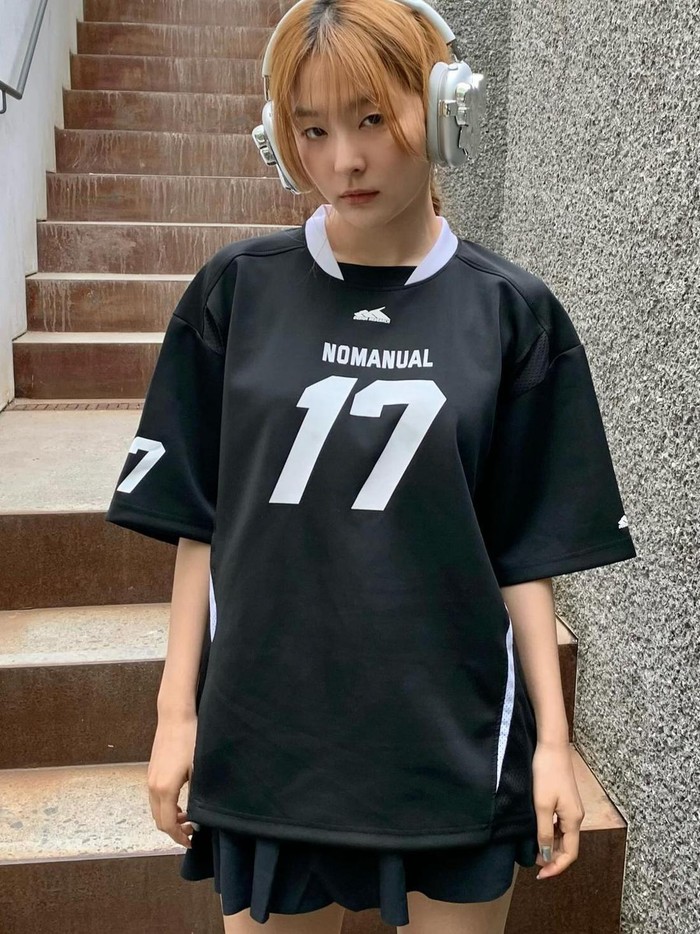 Seulgi tampil mengesankan dalam outfit jersey hitam yang dipadukan dengan rok mini berwarna senada agar terlihat chic. Ia menyelesaikan tampilannya dengan mengenakan headset untuk tampilan yang lebih edgy./ Foto: Elle Korea